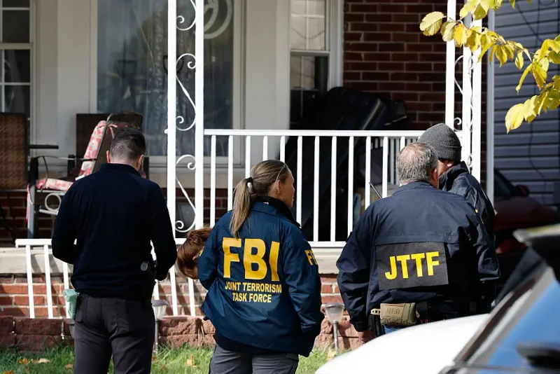 Members of the FBI Joint Terrorism Task Force stand in the front yard as they search a home in Dearborn, Michigan, on October 31, 2025. FBI Director Kash Patel said Friday that the agency had thwarted a "potential terrorist attack" planned in the northern state of Michigan over Halloween weekend. Patel said the FBI arrested multiple subjects. (Photo by JEFF KOWALSKY / AFP) (Photo by JEFF KOWALSKY/AFP via Getty Images)