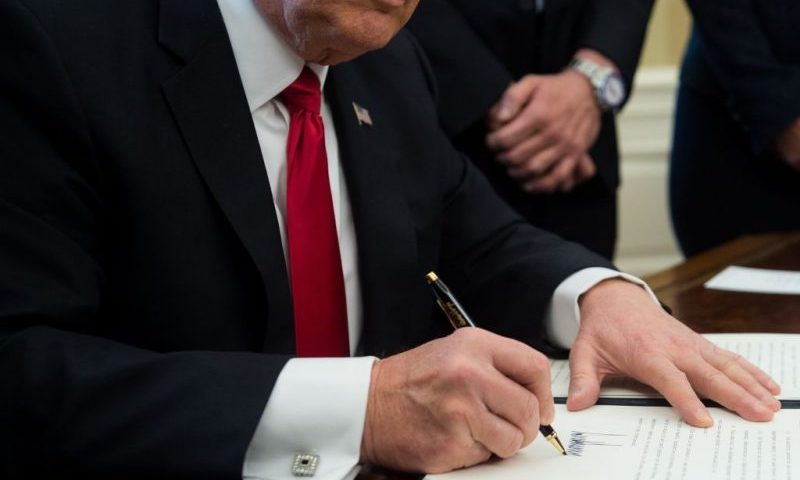 US President Donald Trump signs an executive order with small business leaders in the Oval Office at the White House in Washington, DC on January 30, 2017. / AFP PHOTO / NICHOLAS KAMM (Photo credit should read NICHOLAS KAMM/AFP via Getty Images)