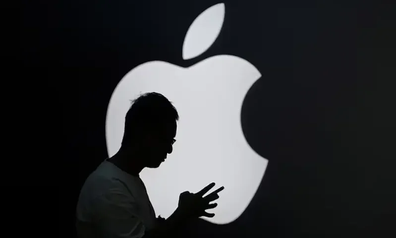 A man check his phone near an Apple logo outside its store in Shanghai, China September 13, 2023. REUTERS/Aly Song/ File Photo