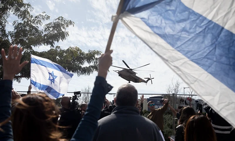Supporters cheer and hold Israeli flags as an Israeli helicopter carrying freed hostages Sagui Dekel Chen and Sasha Troufanov lands at a hospital after they were released from Hamas captivity on February 15, 2025 in Ramat gan, Israel. Hamas informed the Israeli government on Friday that Sagui Dekel Chen, Alexander Sasha Troufanov and Iair Horn would be released today, as part of a ceasefire deal that seemed in jeopardy earlier in the week. (Photo by Amir Levy/Getty Images)