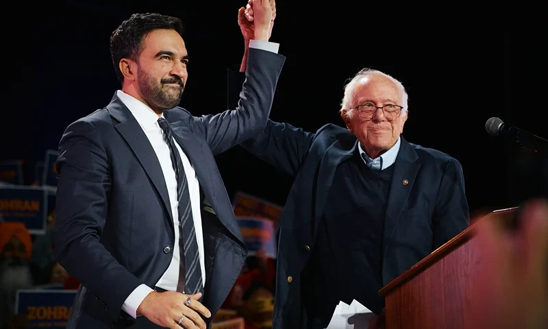 NEW YORK, NEW YORK - OCTOBER 26: New York Mayoral Candidate Zohran Mamdani celebrates with Sen. Bernie Sanders (I-VT) during an election rally with Sanders and U.S. Rep. Alexandria Ocasio-Cortez (D-NY) at Forest Hills Stadium on October 26, 2025 in the Queens borough of New York City. The mayoral election will take place on November 4, 2025. (Photo by Andres Kudacki/Getty Images)