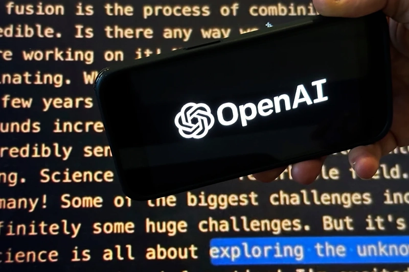 The OpenAI logo appears on a mobile phone in front of a screen showing part of the company website in this photo taken on Nov. 21, 2023 in New York. (AP Photo/Peter Morgan, File)